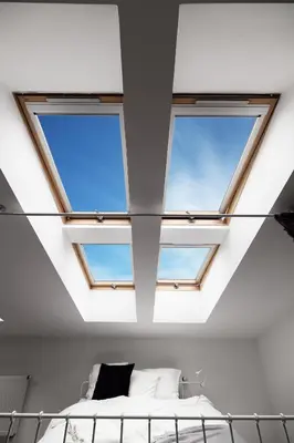 a bedroom with three windows in the ceiling at Bright Modern Studio in the Heart of the Old Town in Kraków