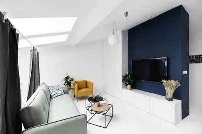 a living room with a couch and a tv at Bright Modern Studio in the Heart of the Old Town in Kraków