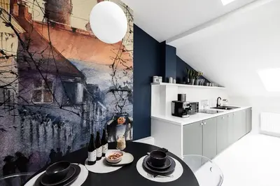 a kitchen with a table and a painting on the wall at Bright Modern Studio in the Heart of the Old Town in Kraków