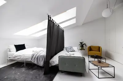 a white bedroom with a bed and a chair at Bright Modern Studio in the Heart of the Old Town in Kraków