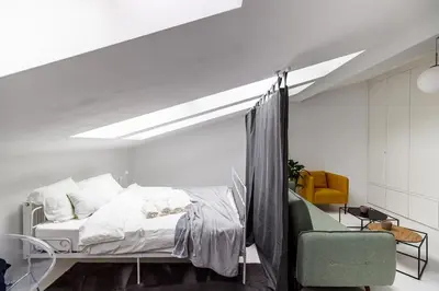 a bedroom with a bed and a yellow chair at Bright Modern Studio in the Heart of the Old Town in Kraków