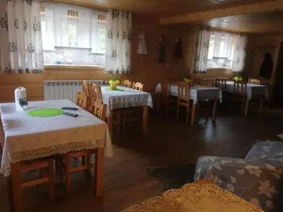 a dining room with tables and chairs and windows at Agroturystyka Anna in Ochotnica Górna