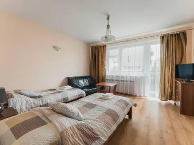 a hotel room with two beds and a television at Nocleg Wadowice in Wadowice