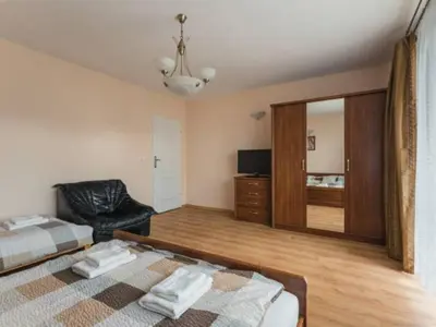 a bedroom with a bed and a chair and a mirror at Nocleg Wadowice in Wadowice