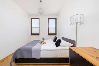 a bedroom with a large bed in a white room at Przestronny i Przytulny Apartament w Krakowie z Parkingiem i Balkonem by Noclegi Renters in Kraków
