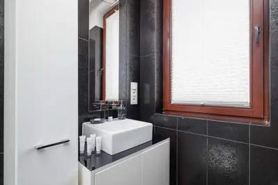 a bathroom with a sink and a mirror at Przestronny i Przytulny Apartament w Krakowie z Parkingiem i Balkonem by Noclegi Renters in Kraków