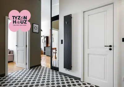 a hallway with a white door and a black and white floor at Bracka by Tyzenhauz in Kraków