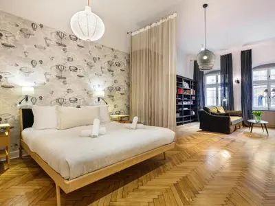 a bedroom with a large bed and a living room at Bracka by Tyzenhauz in Kraków