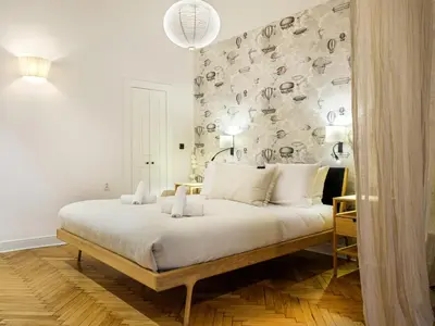 a bedroom with a large white bed with a wall at Bracka by Tyzenhauz in Kraków