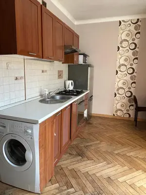 a kitchen with a sink and a washing machine at Retoryka Apt in Kraków