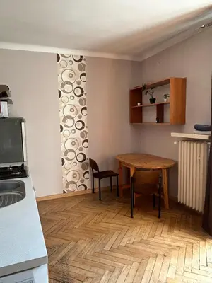 a kitchen with a table and a table and chairs at Retoryka Apt in Kraków