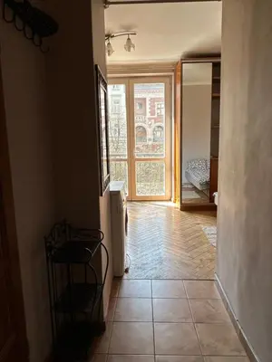 a hallway with a room with a window and a bed at Retoryka Apt in Kraków