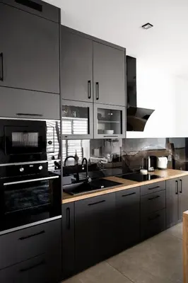 a kitchen with black and white cabinets and appliances at Loft House Rabka dom na wyłączność z jacuzzi SKI&SPA in Rabka