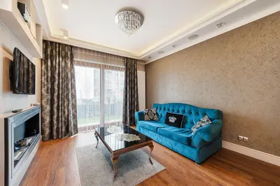a living room with a blue couch and a window at ApartmentPrestige Premium in Kraków