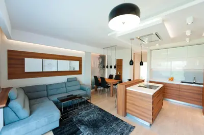 a living room with a blue couch and a table at ApartmentPrestige Premium in Kraków