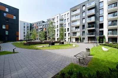 a park with a bench in front of a building at ApartmentPrestige Premium in Kraków