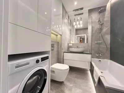 a white bathroom with a washing machine in it at ApartmentPrestige Premium in Kraków
