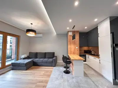 a living room with a couch and a kitchen at ApartmentPrestige Premium in Kraków