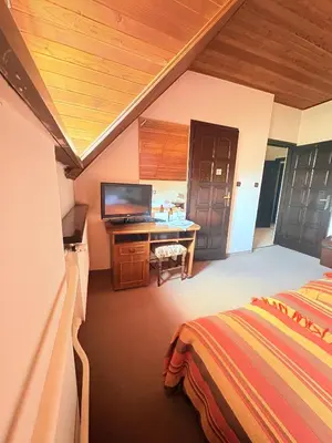 a bedroom with a bed and a desk with a television at Pensjonat Rezydencja Zuzanna Bed&Breakfast Sucha Beskidzka in Sucha Beskidzka