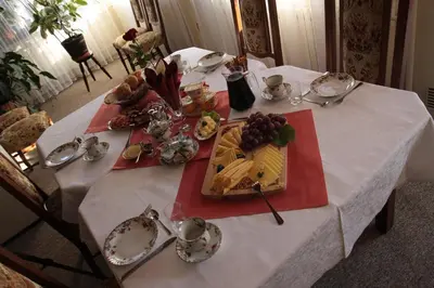 a white table with a plate of food on it at Pensjonat Rezydencja Zuzanna Bed&Breakfast Sucha Beskidzka in Sucha Beskidzka