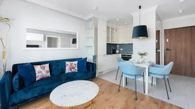 a living room with a blue couch and a table at Riva Verona, Sun & Snow in Kraków