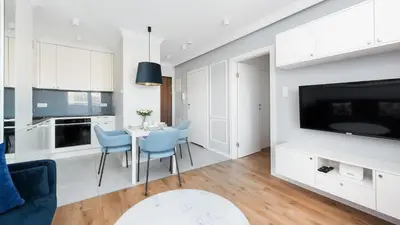 a kitchen and living room with a table and chairs at Riva Verona, Sun & Snow in Kraków