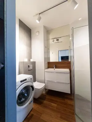 a bathroom with a washing machine and a toilet at Romanowicza Street - Zabłocie - parking free in Kraków