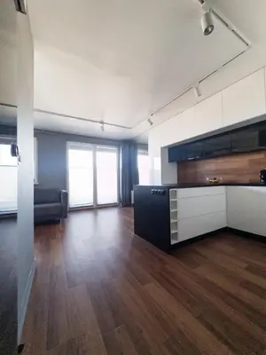 an empty room with a kitchen and a living room at Romanowicza Street - Zabłocie - parking free in Kraków