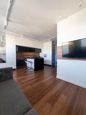 a living room with a couch and a flat screen tv at Romanowicza Street - Zabłocie - parking free in Kraków