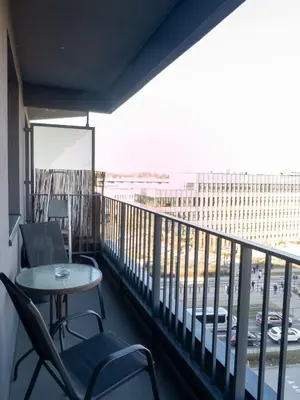 a balcony with a table and chairs and a building at Romanowicza Street - Zabłocie - parking free in Kraków