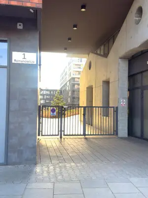 an outside view of a building with a gate at Romanowicza Street - Zabłocie - parking free in Kraków