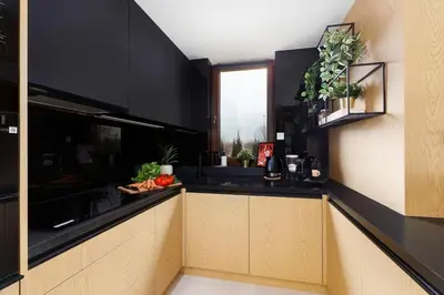 a kitchen with black walls and a black counter top at Ucieknij do luksusu Villa Wola2 in Kraków