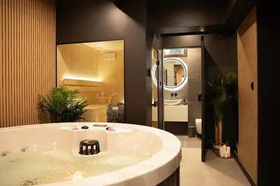 a large bath tub in a bathroom with a mirror at Ucieknij do luksusu Villa Wola2 in Kraków