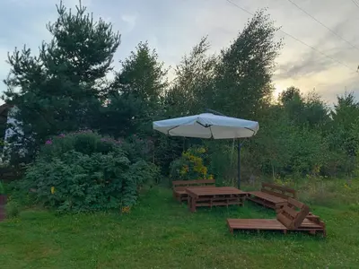 two benches and an umbrella in the grass at Pszczela Oaza in Bulowice