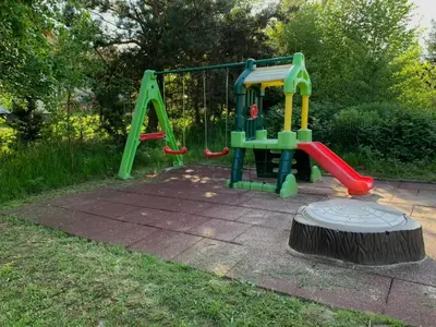 a playground with a slide in a yard at Pszczela Oaza in Bulowice