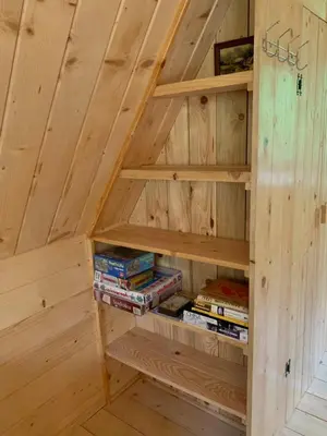 a book shelf in a wooden room with books at Pszczela Oaza in Bulowice
