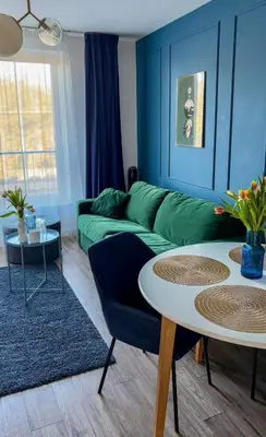 a living room with a green couch and a table at Royal Blue Place Cracow in Kraków