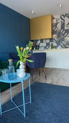 a living room with a table and a kitchen at Royal Blue Place Cracow in Kraków