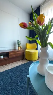 a vase with flowers on a table in a room at Royal Blue Place Cracow in Kraków