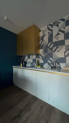 a kitchen with white cabinets and a tile wall at Royal Blue Place Cracow in Kraków