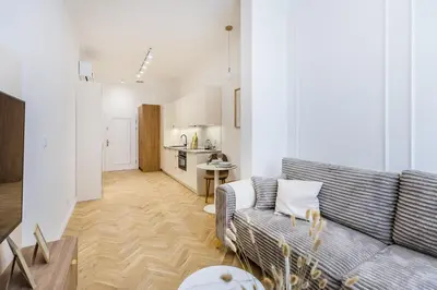 a living room with a couch and a kitchen at Apartament Długa 24 in Kraków