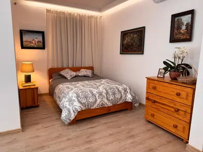 a bedroom with a bed and a wooden dresser at Mieszkanie bez barier, przytulność na każdym kroku in Myślenice