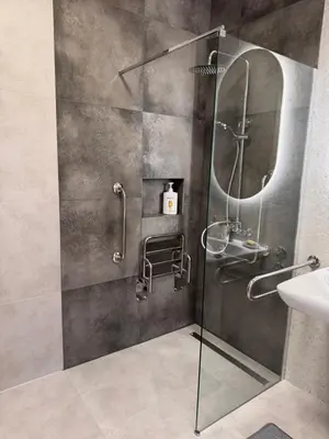 a bathroom with a glass shower with a sink at Mieszkanie bez barier, przytulność na każdym kroku in Myślenice