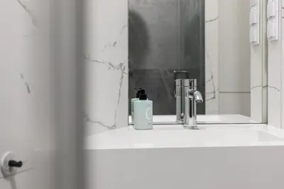 a bathroom sink with a soap dispenser and a mirror at Kossak Residence - by Wawel Castle in Kraków