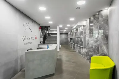 a lobby with a reception desk and a yellow chair at Kossak Residence - by Wawel Castle in Kraków