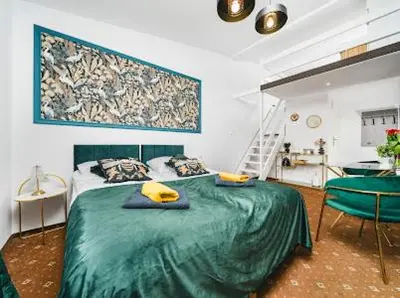 a bedroom with a bed with a green blanket at Queen Bee Apartments Krakow Old Town in Kraków