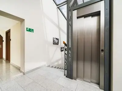 a hallway of a building with a metal door at Queen Bee Apartments Krakow Old Town in Kraków