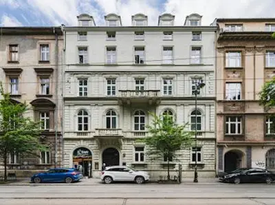 a large building with cars parked in front of it at Queen Bee Apartments Krakow Old Town in Kraków