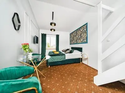 a bedroom with a bed and a couch and a table at Queen Bee Apartments Krakow Old Town in Kraków