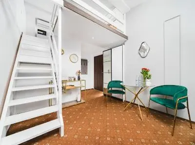 a room with a staircase and a table and chairs at Queen Bee Apartments Krakow Old Town in Kraków